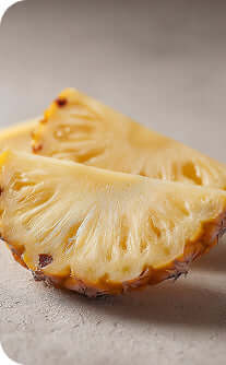 Two pineapple slices on a light brown surface