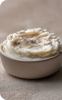 Mashed potatoes in a white bowl on a textured surface