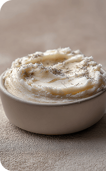Mashed potatoes in a white bowl on a textured surface