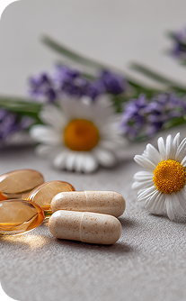 Vitamins, capsules, and flowers on a light surface