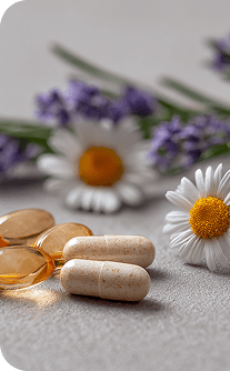 Vitamins, capsules, and flowers on a light surface