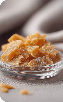 Glass bowl filled with ginger pieces on a neutral background