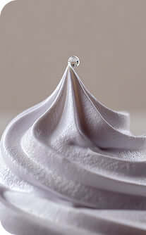 Close-up of a swirl of white frosting on a light background