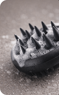 Black scrubber with bristles on a textured surface
