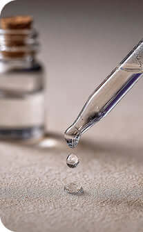Vial with dropper and liquid droplet on a neutral background