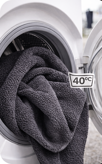 Gray towel inside a washing machine with a 40°C temperature label.