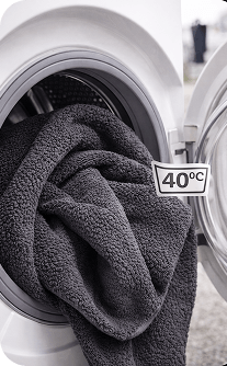 Gray towel inside a washing machine with a 40°C temperature label.