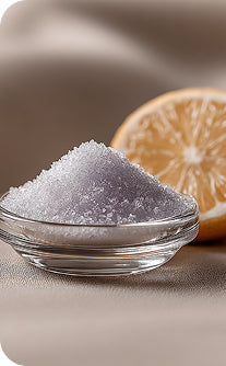Bowl of purple salt with a lemon half on a beige background