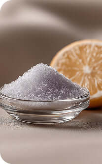 Bowl of purple salt with a lemon half on a beige background