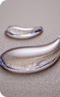 Close-up of two silver teardrop-shaped rings on a textured surface