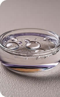 Clear glass container with water droplets on a textured surface