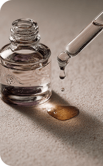 Glass dropper bottle with liquid on a textured surface