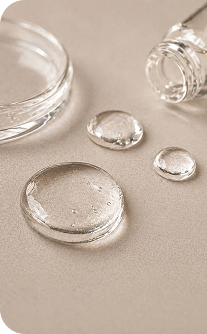 Clear glass containers with water droplets on a beige surface