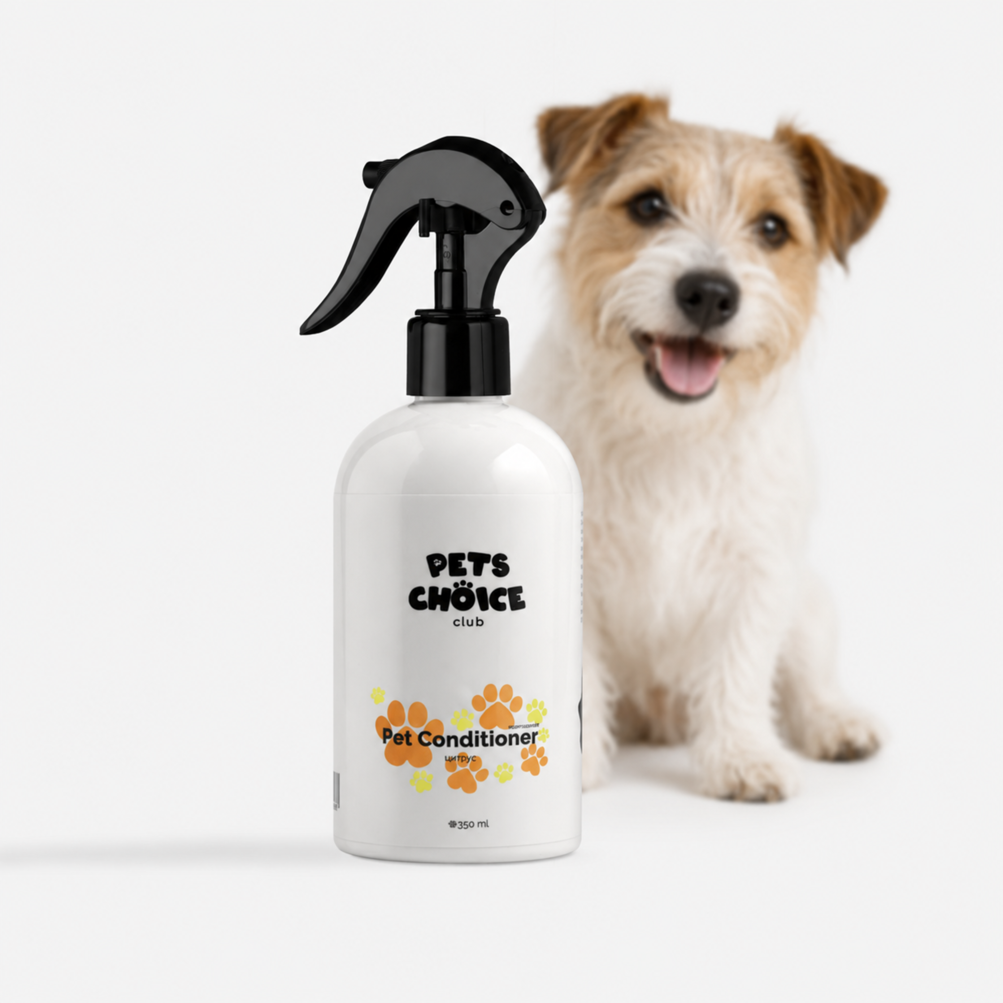 A white spray bottle of Pets Choice Club Pet Conditioner with a black trigger sprayer, shown in front of a small white and tan dog on a light gray background.