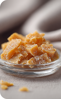 Glass bowl filled with ginger pieces on a neutral background