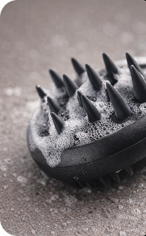 Black scrubber with bristles on a textured surface