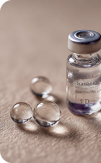 Vial labeled 'Starabil' with droplets on a textured surface