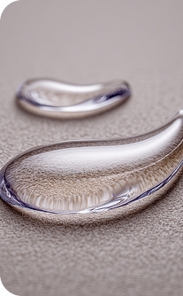 Close-up of two silver teardrop-shaped rings on a textured surface